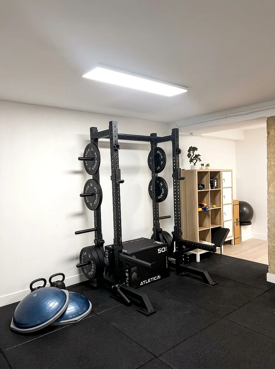 Plateau technique du cabinet : rack à squat, disques, box de saut et coussins d'équilibre